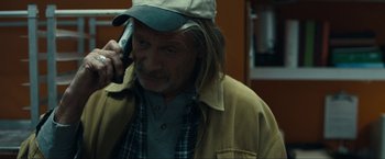 Movie still from “Compliance” (2012), directed by Craig Zobel – A man with long hair talking on a cell phone; Close Up shot, Over the shoulder angle