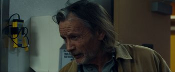 Movie still from “Compliance” (2012), directed by Craig Zobel – An older man with long hair and a beard; Close Up shot, Over the shoulder angle