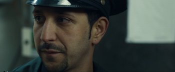Movie still from “Compliance” (2012), directed by Craig Zobel – A man wearing a black hat; Close Up shot, Over the shoulder angle