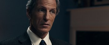 Movie still from “Compliance” (2012), directed by Craig Zobel – An older man wearing a suit and tie; Close Up shot, Over the shoulder angle