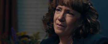 Movie still from “Compliance” (2012), directed by Craig Zobel – A person with curly hair; Close Up shot, Over the shoulder angle