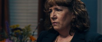 Movie still from “Compliance” (2012), directed by Craig Zobel – An older woman is looking at the camera; Close Up shot, Over the shoulder angle