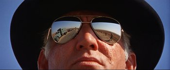 Movie still from “Cool Hand Luke” (1967), directed by Stuart Rosenberg – A man wearing a hat and sunglasses looking into a mirror; Extreme Close Up shot, Low angle