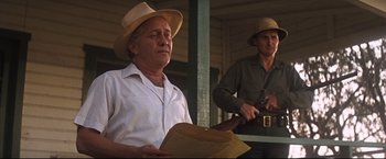 Movie still from “Cool Hand Luke” (1967), directed by Stuart Rosenberg – A man in a hat holding a piece of paper next to another man in a hat; Medium shot, Low angle