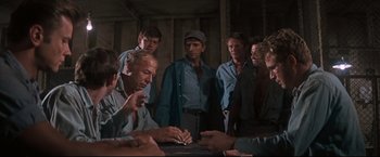 Movie still from “Cool Hand Luke” (1967), directed by Stuart Rosenberg – A group of men standing around a table; Medium shot, High angle