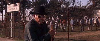 Movie still from “Cool Hand Luke” (1967), directed by Stuart Rosenberg – An old man holding a cane in a field; Close Up shot, Over the shoulder angle