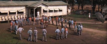 Movie still from “Cool Hand Luke” (1967), directed by Stuart Rosenberg – A group of men standing in front of a building; Extreme Wide shot, High angle
