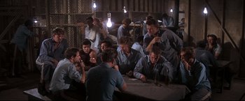 Movie still from “Cool Hand Luke” (1967), directed by Stuart Rosenberg – A group of people sitting around a table; Wide shot, High angle