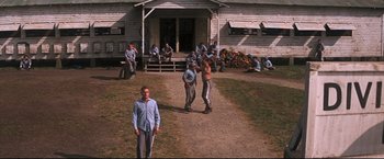 Movie still from “Cool Hand Luke” (1967), directed by Stuart Rosenberg – A group of men standing on top of a dirt road; Wide shot, High angle