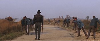 Movie still from “Cool Hand Luke” (1967), directed by Stuart Rosenberg – A group of men playing baseball on a dirt road; Wide shot, Low angle