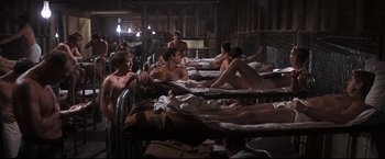 Movie still from “Cool Hand Luke” (1967), directed by Stuart Rosenberg – A group of people sitting on top of a bed; Wide shot, High angle