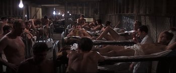 Movie still from “Cool Hand Luke” (1967), directed by Stuart Rosenberg – A group of people laying on mattresses in a room; Wide shot, High angle