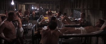 Movie still from “Cool Hand Luke” (1967), directed by Stuart Rosenberg – A group of people laying down in a room; Wide shot, High angle