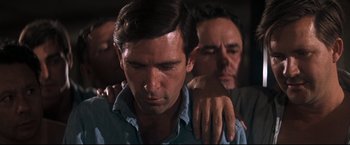 Movie still from “Cool Hand Luke” (1967), directed by Stuart Rosenberg – A man with his hands on his shoulders and another man with his hands on his shoulder; Close Up shot, Low angle
