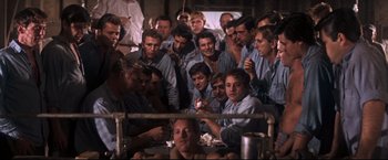 Movie still from “Cool Hand Luke” (1967), directed by Stuart Rosenberg – A group of men sitting in front of each other in a room; Medium shot, High angle