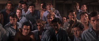 Movie still from “Cool Hand Luke” (1967), directed by Stuart Rosenberg – A group of men sitting in front of each other in a room; Medium shot, High angle