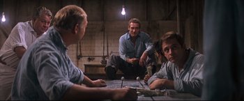 Movie still from “Cool Hand Luke” (1967), directed by Stuart Rosenberg – A group of men sitting around a table; Medium shot, Low angle