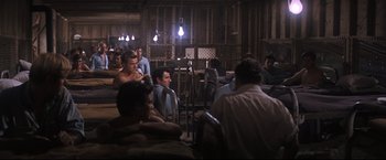 Movie still from “Cool Hand Luke” (1967), directed by Stuart Rosenberg – A group of men sitting in a room with a light bulb; Wide shot, High angle