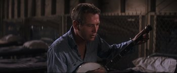 Movie still from “Cool Hand Luke” (1967), directed by Stuart Rosenberg – A person holding a banjo; Close Up shot, Low angle