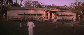 Movie still from “Cool Hand Luke” (1967), directed by Stuart Rosenberg – A group of men standing in front of a building; Extreme Wide shot, Low angle