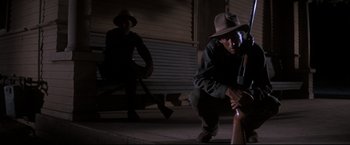 Movie still from “Cool Hand Luke” (1967), directed by Stuart Rosenberg – A man kneeling on the ground holding a baseball bat; Medium shot, Low angle