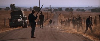 Movie still from “Cool Hand Luke” (1967), directed by Stuart Rosenberg – A group of people walking down a dirt road; Wide shot, Low angle