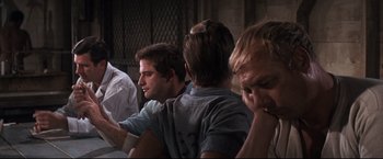 Movie still from “Cool Hand Luke” (1967), directed by Stuart Rosenberg – A group of men sitting around a table; Medium shot, Over the shoulder angle