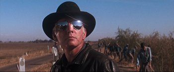 Movie still from “Cool Hand Luke” (1967), directed by Stuart Rosenberg – A man wearing a black hat and a leather jacket; Close Up shot, Low angle