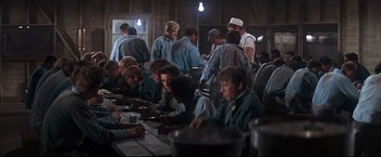 Movie still from “Cool Hand Luke” (1967), directed by Stuart Rosenberg – A group of men sitting at a table eating food; Wide shot, High angle
