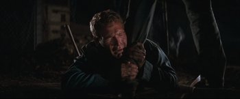 Movie still from “Cool Hand Luke” (1967), directed by Stuart Rosenberg – A man holding onto an umbrella in the dark; Medium shot, Low angle