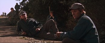 Movie still from “Cool Hand Luke” (1967), directed by Stuart Rosenberg – A group of men sitting on the ground in the woods; Wide shot, High angle