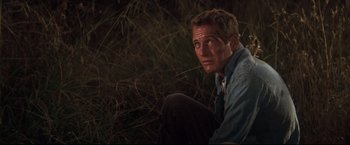 Movie still from “Cool Hand Luke” (1967), directed by Stuart Rosenberg – A person crouching in the grass; Close Up shot, Low angle