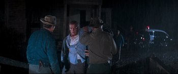 Movie still from “Cool Hand Luke” (1967), directed by Stuart Rosenberg – A man in a blue jacket and a man in a brown hat; Medium shot, Over the shoulder angle