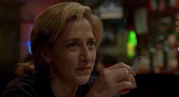 Movie still from “Cop Land” (1997), directed by James Mangold – A person sitting at a table holding a cigarette; Close Up shot, Over the shoulder angle