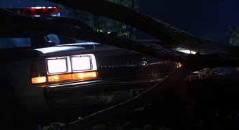 Movie still from “Cop Land” (1997), directed by James Mangold – The back end of an old car at night; Wide shot, Low angle