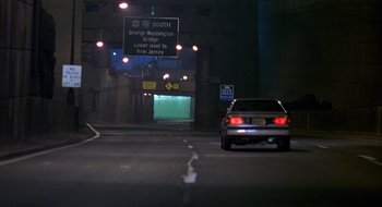 Movie still from “Cop Land” (1997), directed by James Mangold – A car driving down a street at night; Extreme Wide shot, High angle