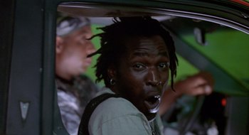 Movie still from “Cop Land” (1997), directed by James Mangold – A man with dreadlocks in the back of a car; Close Up shot, Low angle