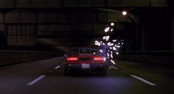 Movie still from “Cop Land” (1997), directed by James Mangold – A car driving down a street at night; Wide shot, Low angle