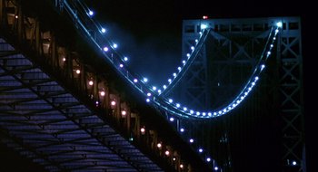 Movie still from “Cop Land” (1997), directed by James Mangold – A view of a bridge lit up at night; Extreme Wide shot, Low angle