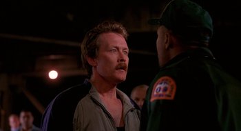 Movie still from “Cop Land” (1997), directed by James Mangold – A man with a mustache is talking to another man; Close Up shot, Over the shoulder angle