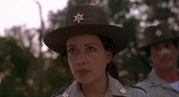 Movie still from “Cop Land” (1997), directed by James Mangold – A woman wearing a sheriff's hat with a star on it; Close Up shot, Low angle