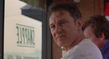 Movie still from “Cop Land” (1997), directed by James Mangold – A person wearing a white t - shirt; Close Up shot, Low angle