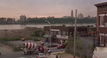 Movie still from “Cop Land” (1997), directed by James Mangold – A street scene with a cement mixer and a building; Extreme Wide shot, High angle