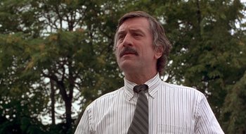 Movie still from “Cop Land” (1997), directed by James Mangold – A person wearing a shirt and a neck tie; Close Up shot, Low angle