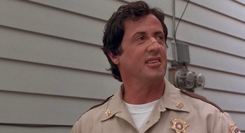 Movie still from “Cop Land” (1997), directed by James Mangold – A man in a sheriff's uniform looking to his left; Close Up shot, Low angle
