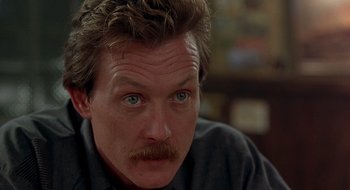 Movie still from “Cop Land” (1997), directed by James Mangold – A person with a mustache; Close Up shot, Low angle