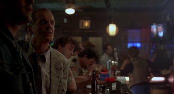 Movie still from “Cop Land” (1997), directed by James Mangold – A group of people sitting at a bar drinking beer; Medium shot, Low angle