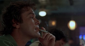 Movie still from “Cop Land” (1997), directed by James Mangold – A man smoking a cigarette in a dark room; Close Up shot, Low angle