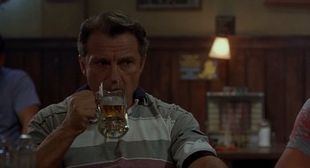 Movie still from “Cop Land” (1997), directed by James Mangold – A man is drinking a glass of beer in a bar; Close Up shot, Low angle