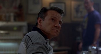 Movie still from “Cop Land” (1997), directed by James Mangold – A person sitting in front of a window; Close Up shot, Low angle